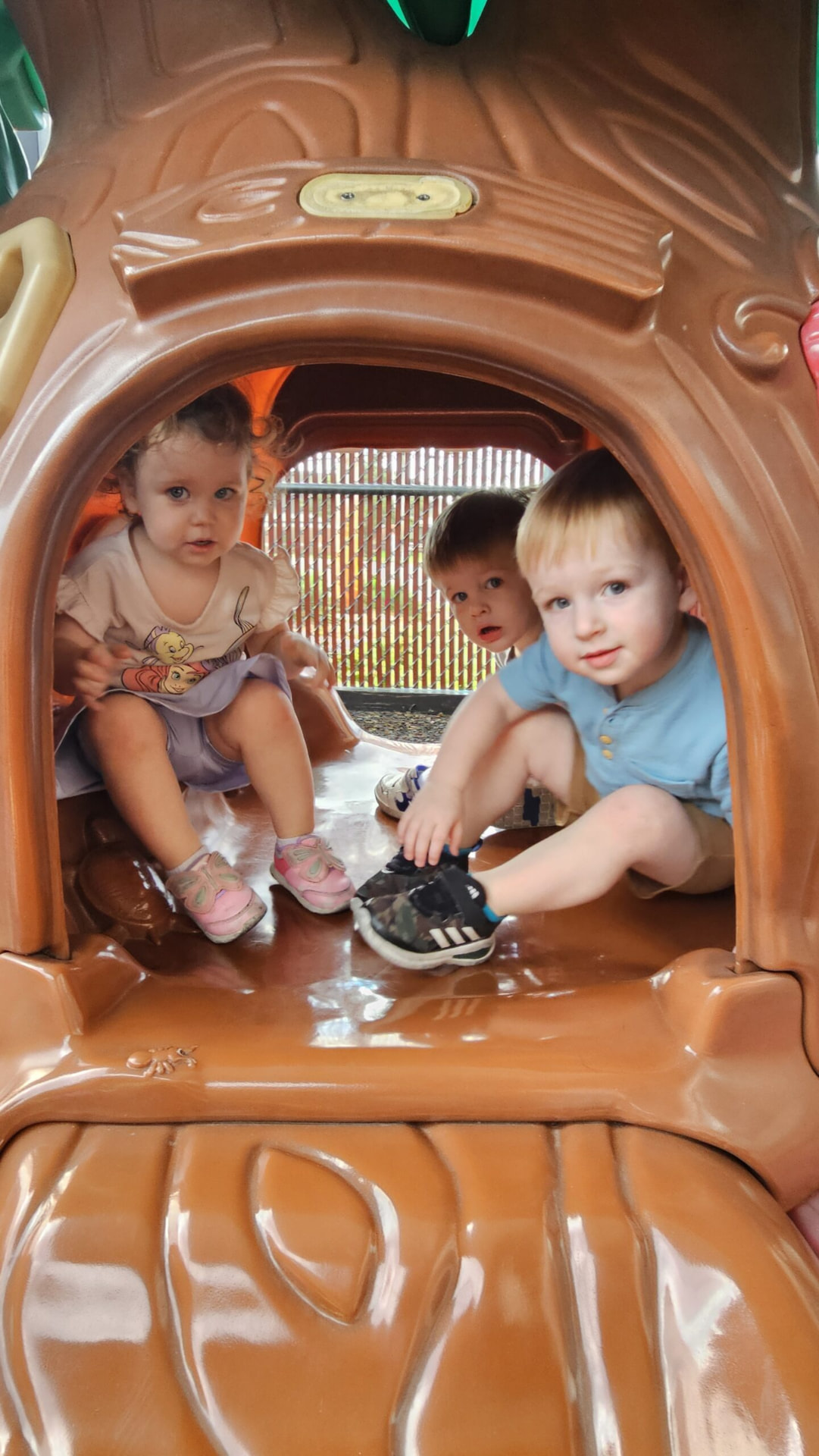Three toddlers playing inside a playground climber at our Crestwood school